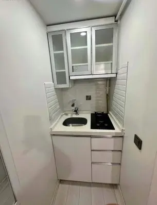 a small kitchen with a sink and white cabinets at Innova Suit Hotel in Istanbul