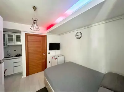 a room with a bed and a kitchen with a clock at Innova Suit Hotel in Istanbul