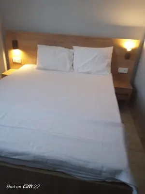 a bed with white sheets and pillows in a room at Tekirdağ Begonya Hotel in Kapaklı