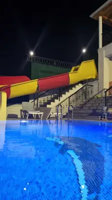 a water slide in a swimming pool at night at Luxury Family Villa with Private Pool & Slide in Gemlik