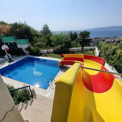 a pool with a slide in front of a house at Luxury Family Villa with Private Pool & Slide in Gemlik