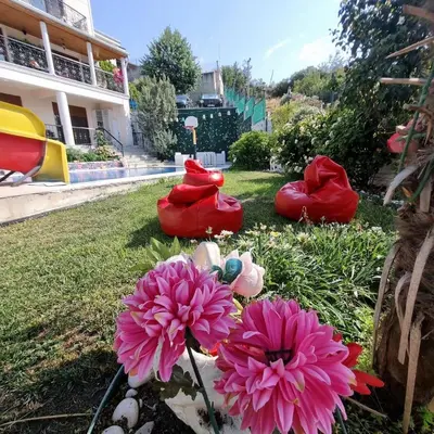 a group of flowers in the grass near a house at Luxury Family Villa with Private Pool & Slide in Gemlik