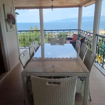 a table and chairs on a balcony with a view of the ocean at Luxury Family Villa with Private Pool & Slide in Gemlik