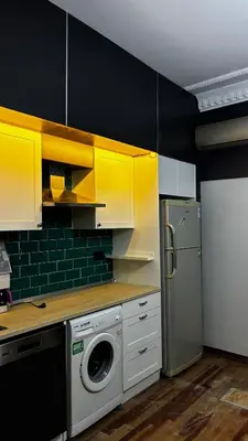a kitchen with a washing machine and yellow cabinets at Taksim Green Flat Apartment 2 in Istanbul