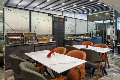 a restaurant with tables and chairs and a kitchen at Hotel De Bonte in Istanbul