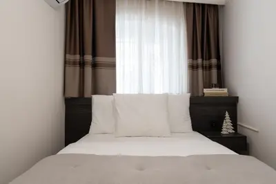 a bedroom with a bed with white pillows and a window at Premium Family House for 10 Near Taksim in Istanbul