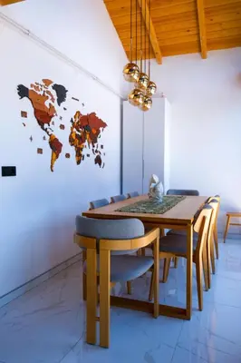a dining room table and chairs with a world map on the wall at Villa Wonka Sapanca Sıcak Havuz in Sapanca
