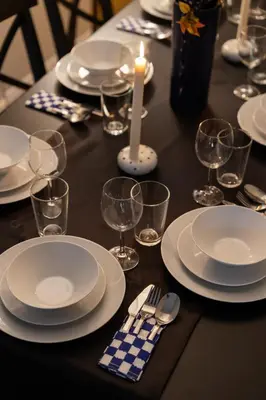 a table with plates and glasses and a candle on it at Renovated Flat near Tram All Rooms AC in Istanbul