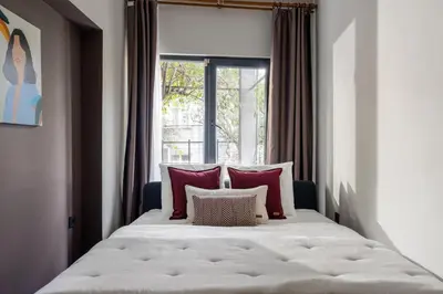 a large bed with red pillows and a window at Renovated Flat near Tram All Rooms AC in Istanbul