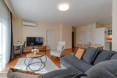 a living room with a blue couch and a table at Spacious 1-Bedroom Apartment with Bosphorus View in Istanbul