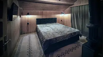 a bedroom with a bed in a wooden room at Villa Nest Uludağ in Hüseyinalan