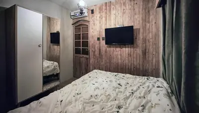 a bedroom with a bed and a tv on a wooden wall at Villa Nest Uludağ in Hüseyinalan