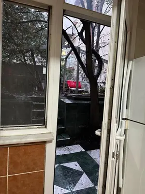 an open door to a yard with a tree at Twin Double X2 Room in Istanbul