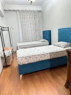 two beds in a room with wooden floors at Twin Double X2 Room in Istanbul