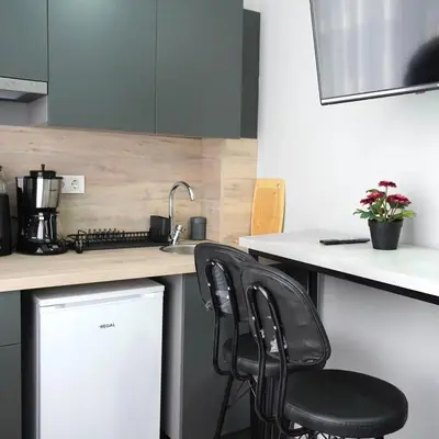 a kitchen with two black chairs at a counter at Accommodation Near the Bull Statue in Kadikoy in Istanbul