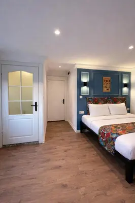 a bedroom with two beds and a white door at taksimrosboutique in Istanbul