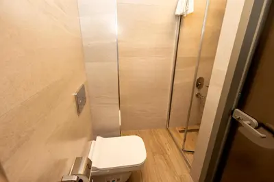 a small bathroom with a toilet and a shower at The Diamond City Hotel Yenikapı in Istanbul