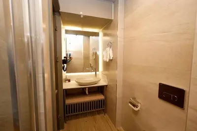 a small bathroom with a sink and a mirror at The Diamond City Hotel Yenikapı in Istanbul