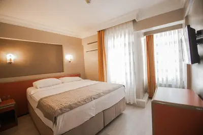 a bedroom with a large bed and a large window at Sahinler Hotel in Istanbul