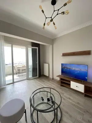 a living room with a flat screen tv and a table at Breathtaking view apartment in Istanbul