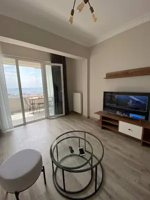 a living room with a glass table and a tv at Breathtaking view apartment in Istanbul