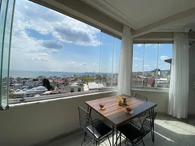 a table and chairs in a room with a large window at Breathtaking view apartment in Istanbul