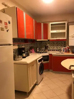 a kitchen with red cabinets and a white refrigerator at Apartment on Pier Loti street with a nice view in Istanbul