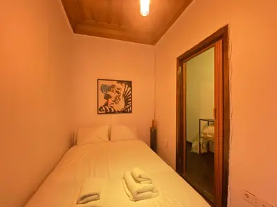 a small bedroom with a bed and a mirror at Historic Lütfi Pasha House in Balat 2BR in Istanbul