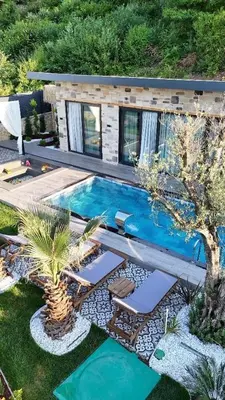 an overhead view of a swimming pool with chairs and a palm tree at Rubyy Resort Luxury Stone Villa with Private Pool in Kartepe