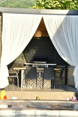 a room with a table and chairs and curtains at Rubyy Resort Luxury Stone Villa with Private Pool in Kartepe