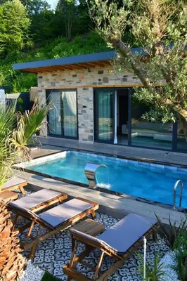 a swimming pool in a backyard with a house at Rubyy Resort Luxury Stone Villa with Private Pool in Kartepe