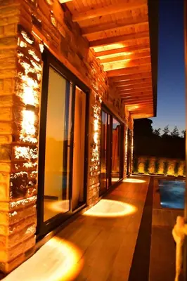 a house with a deck with lights on it at Rubyy Resort Luxury Stone Villa with Private Pool in Kartepe
