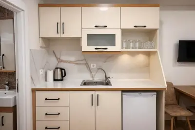 a small kitchen with white cabinets and a sink at VALENCE SUITES Taksim in Istanbul