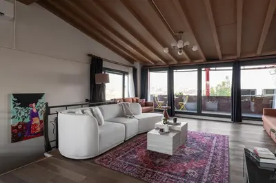 a living room with a white couch and a rug at Iconic Sea View Duplex w Terrace in Balat in Istanbul