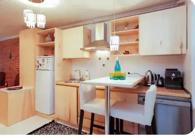 a kitchen with a white refrigerator and a table with chairs at Two seperate apartments for friends and families in Istanbul