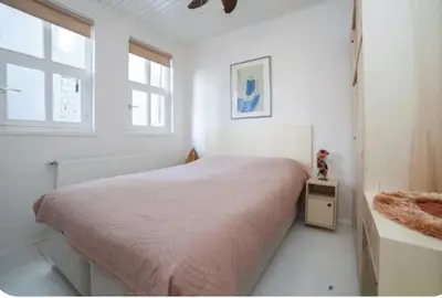 a white bedroom with a bed and a window at Two seperate apartments for friends and families in Istanbul