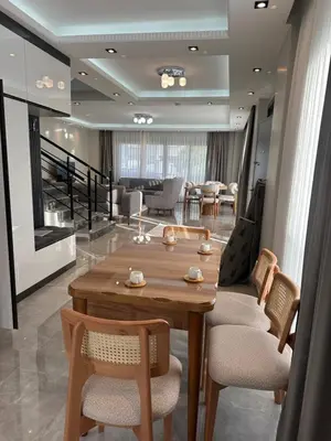 a living room with a wooden table and chairs at Villa life in Gümüşyaka