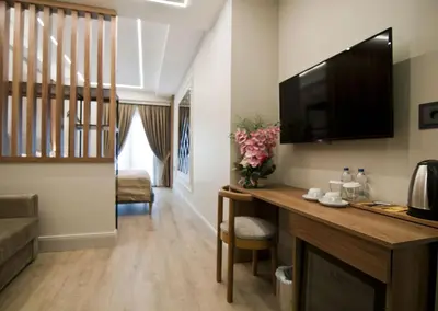 a living room with a desk with a television on the wall at Forty Nişantaşı Hotel & SPA in Istanbul