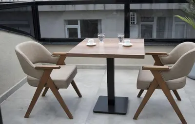 a wooden table with two chairs and two glasses on it at Forty Nişantaşı Hotel & SPA in Istanbul