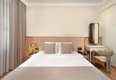 a bedroom with a large white bed and a desk at Atik Hotel Nişantaşı in Istanbul