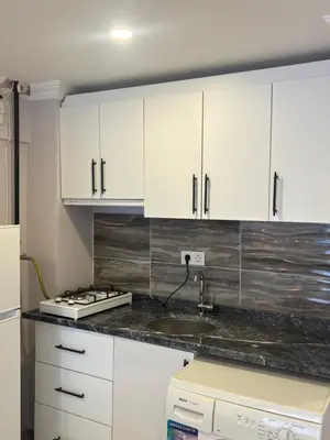 a kitchen with white cabinets and a sink at Fly Apartment Hotel in Istanbul