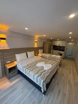 a large bedroom with two beds and a kitchen at Fly Apartment Hotel in Istanbul