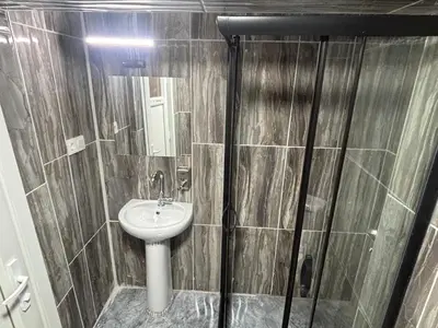 a small bathroom with a sink and a shower at Fly Apartment Hotel in Istanbul
