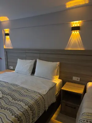 a bedroom with a bed and two lights on the wall at Fly Apartment Hotel in Istanbul