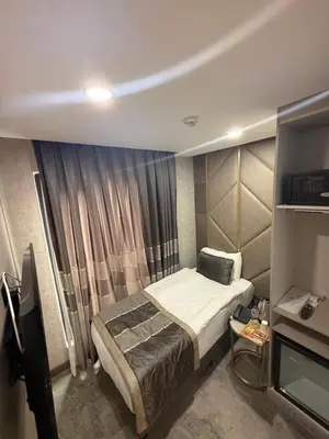 a small bedroom with a bed and a window at Elysia Plus in Istanbul
