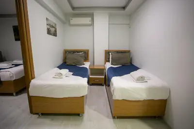 two beds in a room with a mirror at Güven House İstanbul in Istanbul