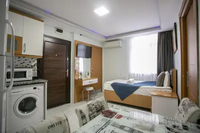 a small bedroom with a bed and a washing machine at Güven House İstanbul in Istanbul