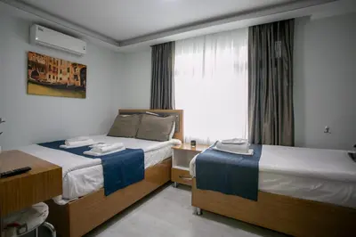 a hotel room with two beds and a window at Güven House İstanbul in Istanbul