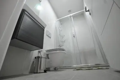 a bathroom with a toilet and a glass shower at Alyon Hotell in Istanbul