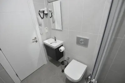 a bathroom with a toilet and a sink and a mirror at Alyon Hotell in Istanbul